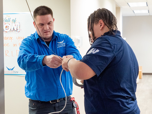 Ho-Chunk, Inc., Apprenticeship Program participant Marquez Bass (right) works with Information Technology Technician Blade Smith to run network cable at one of the company's buildings in Winnebago, Nebraska. (Ho-Chunk, Inc.)