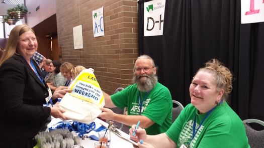 PHOTO: Randy Kurtz and Karen Mork, members of the Washington Federation of State Employees, help with registration at the Washington State Labor Council convention. Donations are also being collected for wildfire relief efforts in the area. Photo credit: Tim Welch