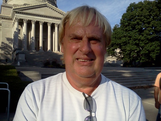 PHOTO: Veterans, Democrats and union members such as Tim Millne protested against state Sen. Evan Jenkins skipping his third veterans affairs committee meeting in a row to attend a high-dollar fundraiser with Karl Rove at a Huntington country club. Photo by Dan Heyman.