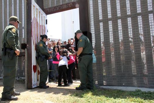 PHOTO: Grandmother Yolanda Verona hugs granddaughter Frida Villagomez at the border fence in Friendship Park at Border Field State Park near San Diego. Photo credit: Maria Teresa Fernandez/Border Angels.