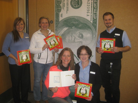 Employees of Community Financial Credit Union help unload donated copies of the book 