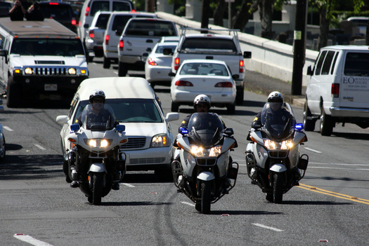 A trio of motorcycle officers leads the funeral procession for a fellow  officer recently killed in the line of duty. (Hako/iStockphoto)