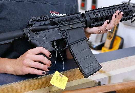 A customer examines an AR-15 semi-automatic rifle recently in a gun store. (Frey/GettyImages)