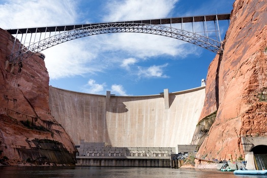 The Glen Canyon Dam towers 710 feet above the original Colorado River channel, producing hydroelectric power and impounding Lake Powell as a water storage reservoir. (Jason/Adobe Stock) 