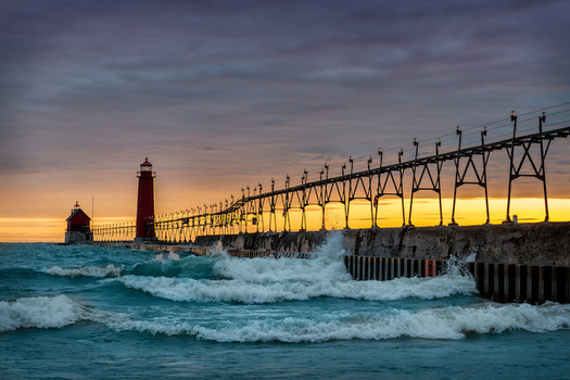 Grand Haven South Pier in Grand Haven, Mich. A new report says more intense storms and heavy flooding are putting Michigan residents and businesses at risk. (Adobe Stock)