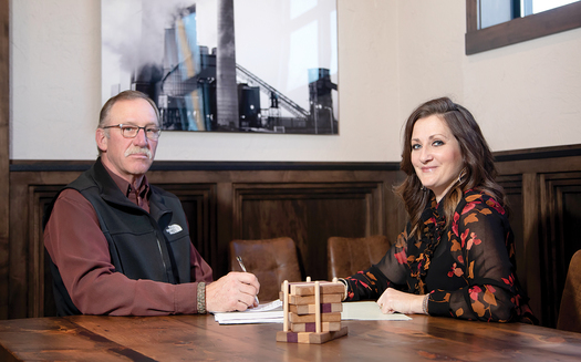 Christie Obenauer (R), president and CEO of Union State Bank of Hazen, meets with Matt Clarys (L) of Western Steel Builders. Partnering with the Bank of North Dakota, Obenauer's small bank has been able to finance several large projects in her town. (Justine Wiedrich)