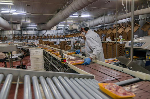 Tight working conditions on production lines in meat and poultry processing facilities make it impossible for workers to adhere to 6-foot distancing. (Adobe Stock)