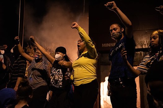 Protesters gather outside the burning Minneapolis 3rd Police precinct on May 28, 2020. (Wikimedia Commons)