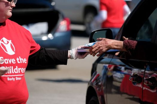 A volunteer with Save The Children hands out school supplies in California as part of the RISE initiative. (Shawn Millsaps/Save the Children)