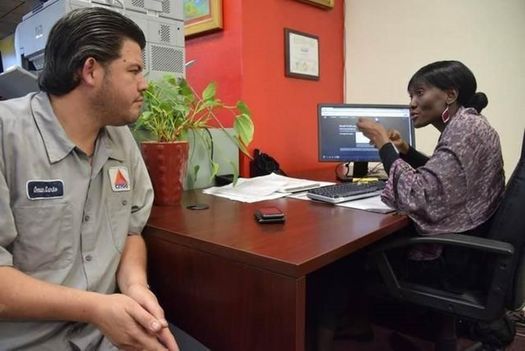Navigator Natalie M. and consumer Omar Luna at Sant La Haitian Neighborhood Center review Luna's health-insurance options. (Epilepsy Florida) 