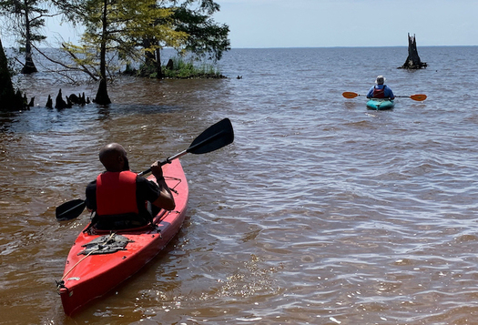 Bertie County Manager Juan Vaughan II and retired county manager Scott Sauer take to the water during the Bertie Beach grand opening in June 2019. (Sarah Tinkham/TGOW)