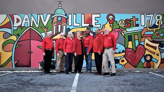 AARP volunteers pose in front of the downtown Danville Community Challenge mural in 2018. (Adobe Stock)