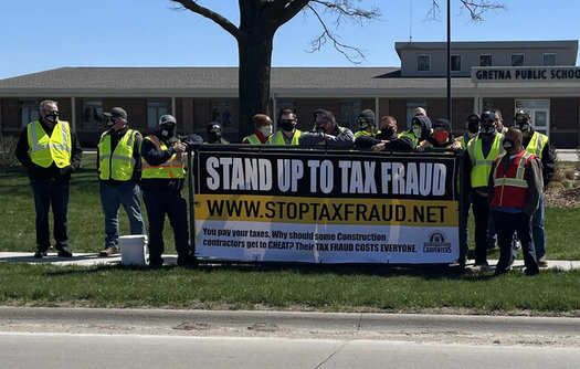 Workers protest tax fraud in the construction field at a school administration building in Gretna, Neb. (Eric Leanos/NCSRCC)