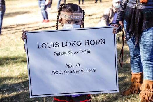 A young girl holds the name of an Indigenous teen tied to a former Native American boarding school in Rapid City. (SiouxSanLands)