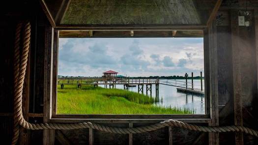 Open windows in the dock house at Bowen's Island look out on the Folly River and surrounding marsh, on Aug. 11, 2021. (Jason Lee)