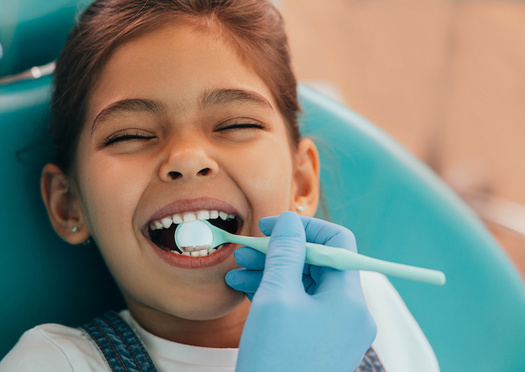 The American Association of Pediatric Dentists recommends children receive a regular dental cleaning and exam every six months, starting when their first tooth comes in. (Adobe Stock)