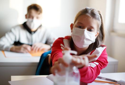 Arkansas researchers say face masks, combined with vaccinations and proper handwashing, can help keep COVID cases down in school settings. (Adobe Stock)