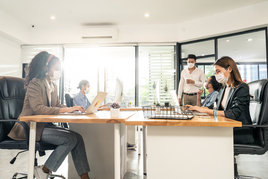 The Centers for Disease Control and Prevention recommends employees wear a face mask while at work. (Adobe Stock)