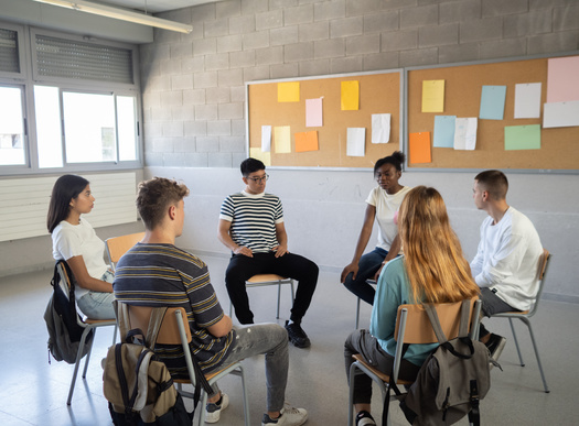 Beyond direct counseling, school social workers will sometimes hold group discussions with students as they try to cope with a tragic incident on campus. (Adobe Stock)