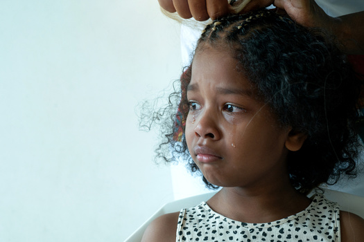 Black people, especially women and girls, have endured countless hair services, sometimes painful and damaging to the hair, to maintain hairstyles that might make them less likely to encounter discrimination. (chomplearn_2001/Adobe Stock)