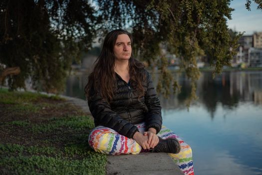 Quinn Redwoods sits by the water at Lake Merritt in Oakland, one of the locations where people from Mask Oakland have distributed masks to protect people from smoke during and following wildfires. (Photo by Nina Thompson for YR Media and CatchLight Local as part of a reporting collaboration with Grist and Next City)