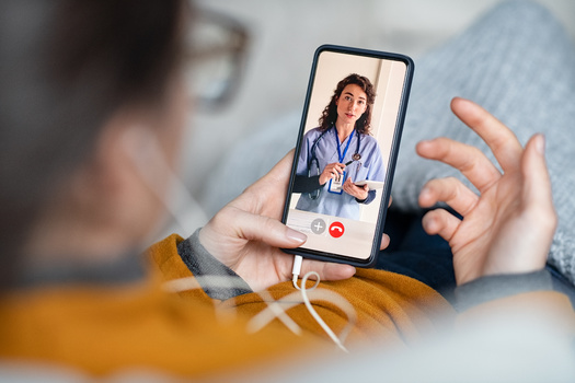 Experts recommend checking into telehealth offerings when researching health plans ahead of the open-enrollment period. (Rido/Adobestock)