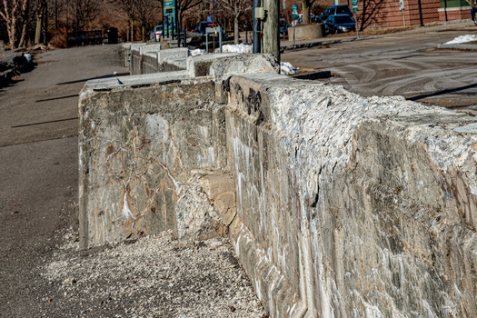 Extremes of hot and cold weather have taken their toll on a concrete barrier along Binghamton's Riverwalk. Concrete crumbles between the stones of the wall in upstate New York. (Chet Wiker/Adobe Stock)
