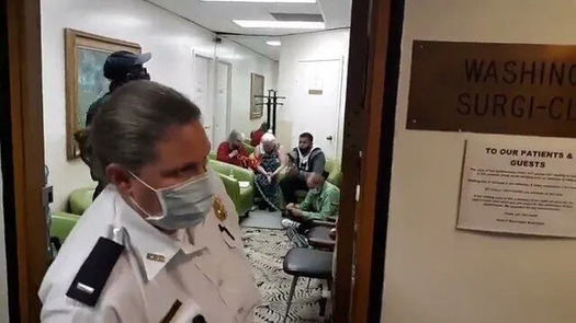 A police officer stands in the doorway of the Washington Surgi-Center during the clinic blockade on Oct. 22, 2020. (We Engage)