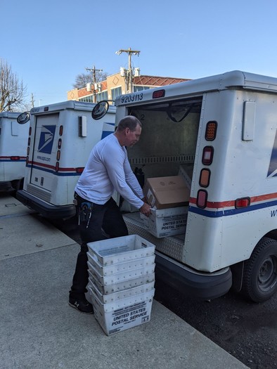 Bryce Shanklin, a Williamson County career rural mail carrier, unloads the U.S. Postal Service vehicle he uses for delivering mail. (Jeremy Woodard)