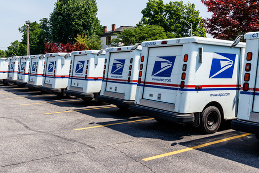 Bryce Shanklin, a career rural mail carrier, in the U.S. Postal Service vehicle he uses for delivering mail. In the second year of USPS' 10-year 'Delivering For America' plan, 50,000 workers were converted from non-career positions to employee roles. (Adobe Stock)
