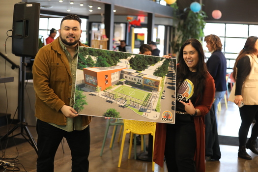 Attendees at a recent COPAL event hold the design of a proposed Latino Center for Community Engagement in the Twin Cities. The organization hopes to have the facility up and running by 2026. (Photo courtesy COPAL)