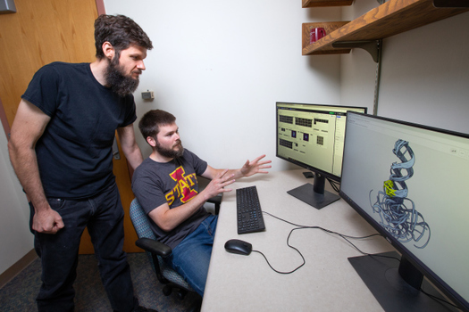 Iowa State University Assistant Biochemistry Professor Walter Moss and graduate student Jake Peterson discuss a computer rendering of an RNA molecule. (Iowa State University)