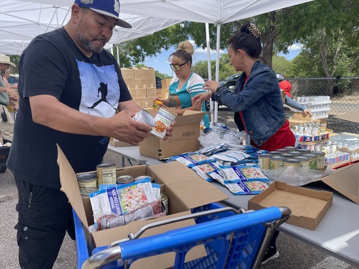 The grandparent of a multi-generational family with children attending Albuquerque's Los Padilla Elementary School picks up food at a monthly free food distribution site. (photo courtesy Roadrunner) 