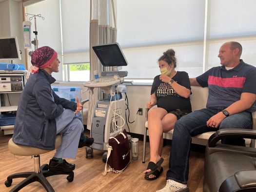 Labor and Delivery doctor Taylor Swartz talks with a pregnant patient and her husband at Mahaska Health Hospital in Iowa. (Tony Leys/KFF Health News) 