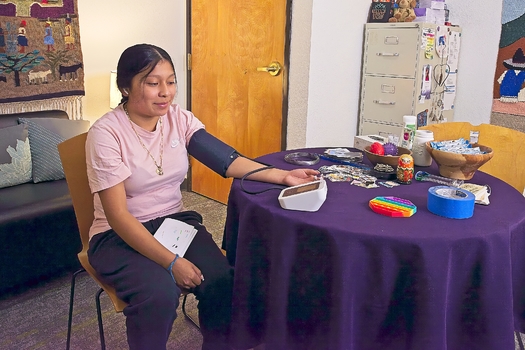 A student at Portland Opportunities and Industrialization Center uses the organization's new self-measuring blood pressure cuff. (American Heart Association)