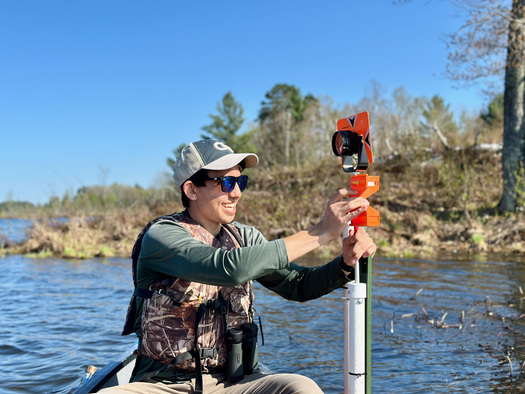 Eric Greenlee, a student from Georgia Tech, installs water-level sensors in lakes at Lac du Flambeau to help monitor wild rice beds. (Photo courtesy Naomi Blinick)