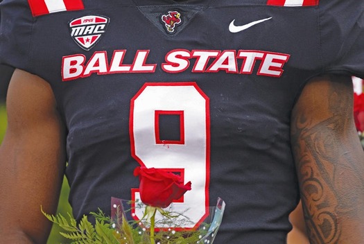 Ball State linebacker Kieonte Newson holds a rose for his mother on Senior Day, a moment of restoration after earning the number nine. (T Slaughter/Daily News)