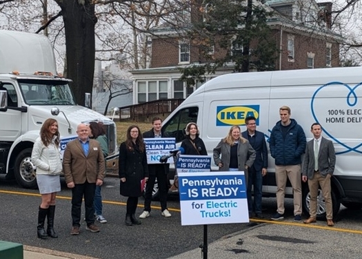 Members of the Cleans Trucks Philadelphia Coalition stand in front of clean energy-powered electric trucks and vans during a Philadelphia news conference on Tuesday. (The Partnership Project)