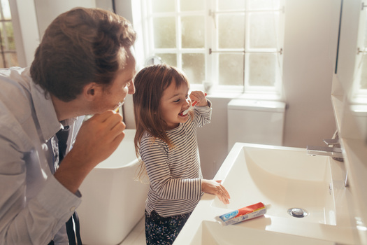 Adults can model proper brushing for their children by brushing alongside them. (Jacob Lund/Adobe Stock)
