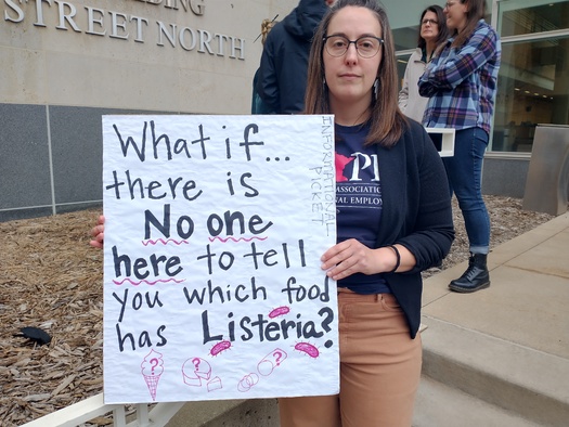 Minnesota public health worker Amy Saupe, who is being laid off because of federal cuts, holds a sign at a demonstration in St. Paul on Thursday. (Mike Moen)