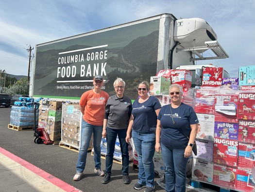 Workers pose in front of supplies in Wasco County. (Columbia Gorge Food Bank)