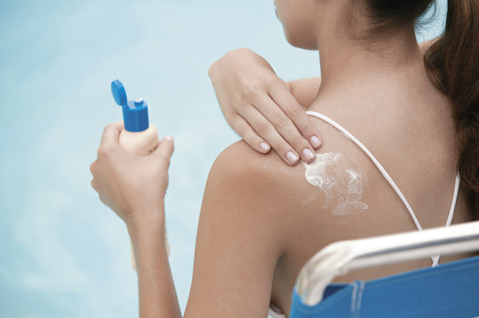 PHOTO: Woman putting on sunscreen.