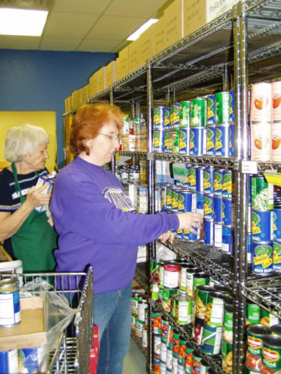 PHOTO: Keystone staff stocking food shelf. Courtesy of Hunger Solutions