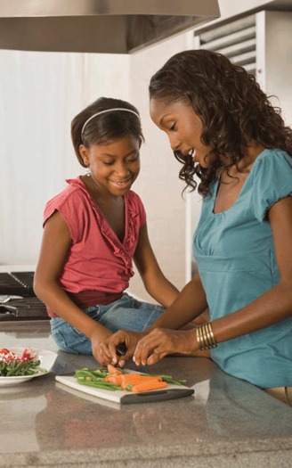 Regular activities like cooking and eating together can provide a consistent secure base for children   Photo courtesy of CDC