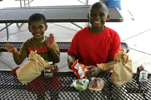 PHOTO: Jaylen and Aaron enjoy their lunches in a St. Louis park. A new report from the Food Research & Action Center says fewer Missouri children who need these summer meals are receiving them. Photo courtesy Operation Food Search.