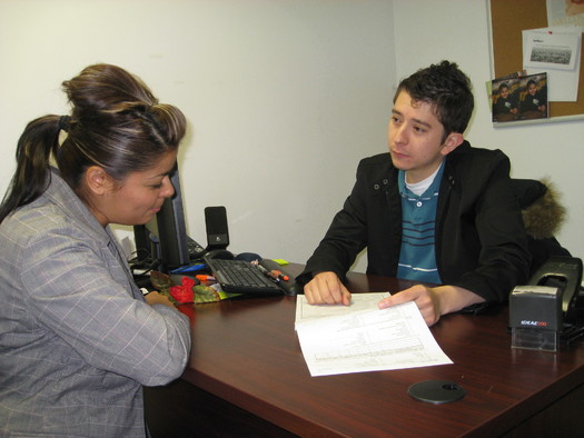 PHOTO: Utah's Community Health Centers are already accustomed to doing outreach work with patients. Here, AmeriCorps worker Erik Perez explains a CHIP application to a local mom. Courtesy AUCH. 