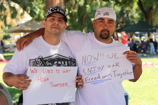PHOTO: Two men hold signs describing how treatment and recovery has changed their lives. A new state audit says only about half of those released from prison who need substance abuse treatment are getting it. Courtesy PSJ.