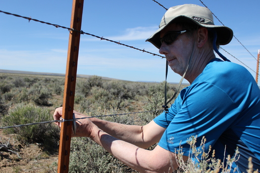 PHOTO: Richard Brandt, Portland, secures a new wire on a boundary fence at Hart Mountain National Antelope Refuge in southern Oregon. Replacing the bottom line of barbed wire with smooth wire makes the fencing safer for the antelope that migrate through the area. Photo courtesy Oregon Natural Desert Assn.