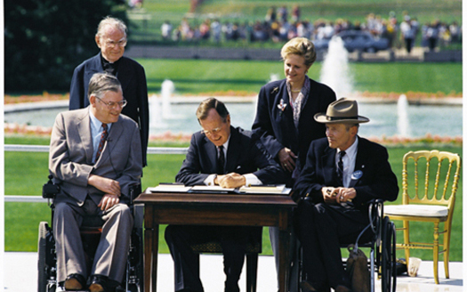 PHOTO: President George H.W. Bush signs the Americans with Disabilities Act into law on July 26, 1990. Photo credit: Wikimedia / Public Domain.