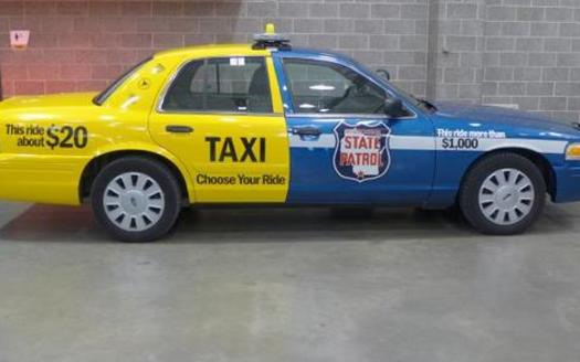PHOTO: This car was painted up by Wisconsin law enforcement authorities to graphically demonstrate the difference in dollar cost between taking a taxi home after having had too much to drink, rather than put the public at risk by drunken driving and getting arrested for it. (Photo credit: Gilman Halsted, WPR)